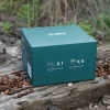 Комплектът кошници Outin Nano, включващ лъжици смляно кафе и филтърни торбички, лежи елегантно върху дънер, заобиколен от разпръснати кафеени зърна.