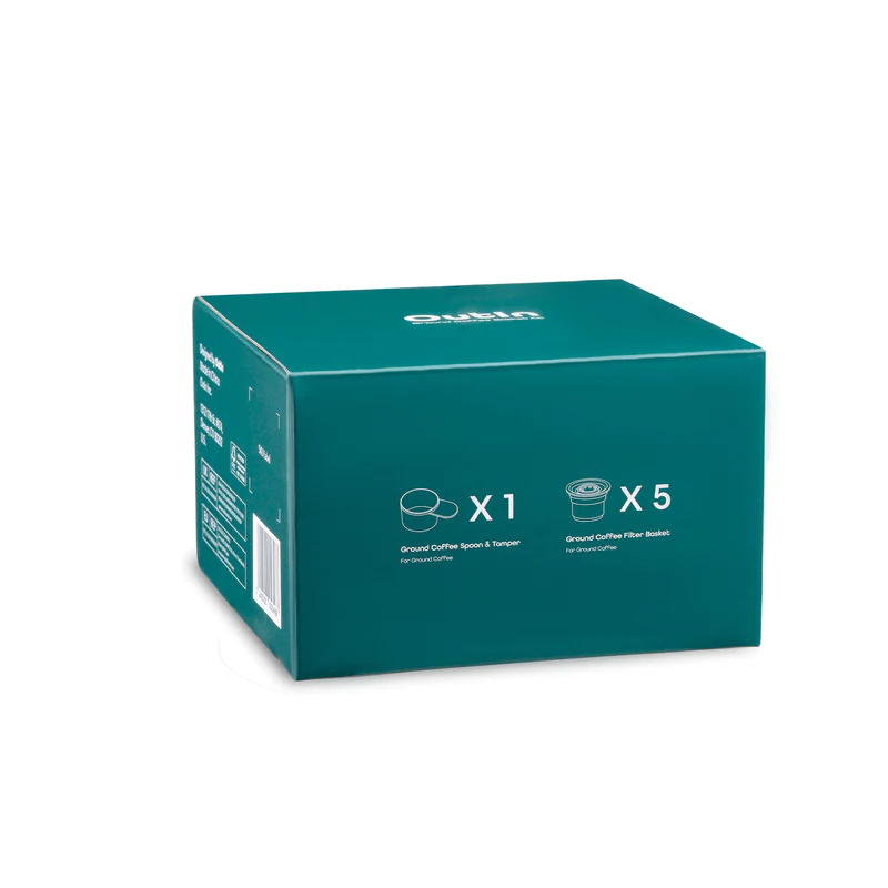 Зелената кутия Комплект кошници Outin Nano включва елегантни продуктови икони и текст, подчертаващ нейното съдържание: една лъжица за кафе и тампон, заедно с пет филтърни кошници за кафе.