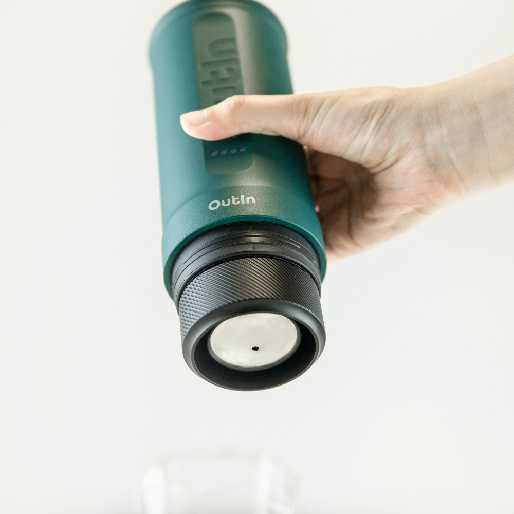 Ръка държи Комплекта за двойно еспресо Nano Basket Plus, наливайки течност в чаша отдолу.