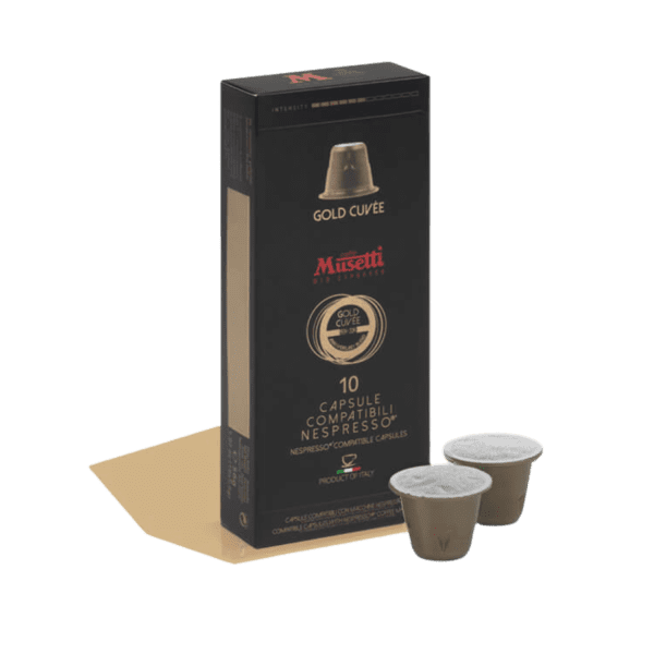 Кутия Кафе капсули Musetti® Gold Cuvée, съвместима със системата Nespresso и идеална за всяко Outin приключение, е елегантно изложена с две капсули, разположени до нея.