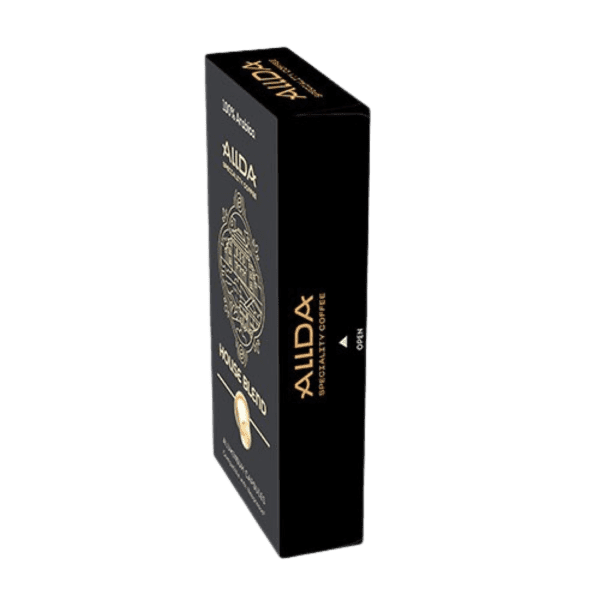 Елегантна черна правоъгълна кутия от Кафе капсули ALLDA Specialty Coffee HOUSE BLEND 100% Арабика, с елегантни златни букви, е поставена на прозрачен фон. Перфектни за уютни сутрини на закрито или приключения на открито, тези съвместими с Nespresso капсули обещават да подобрят вашето кафе изживяване, където и да сте.